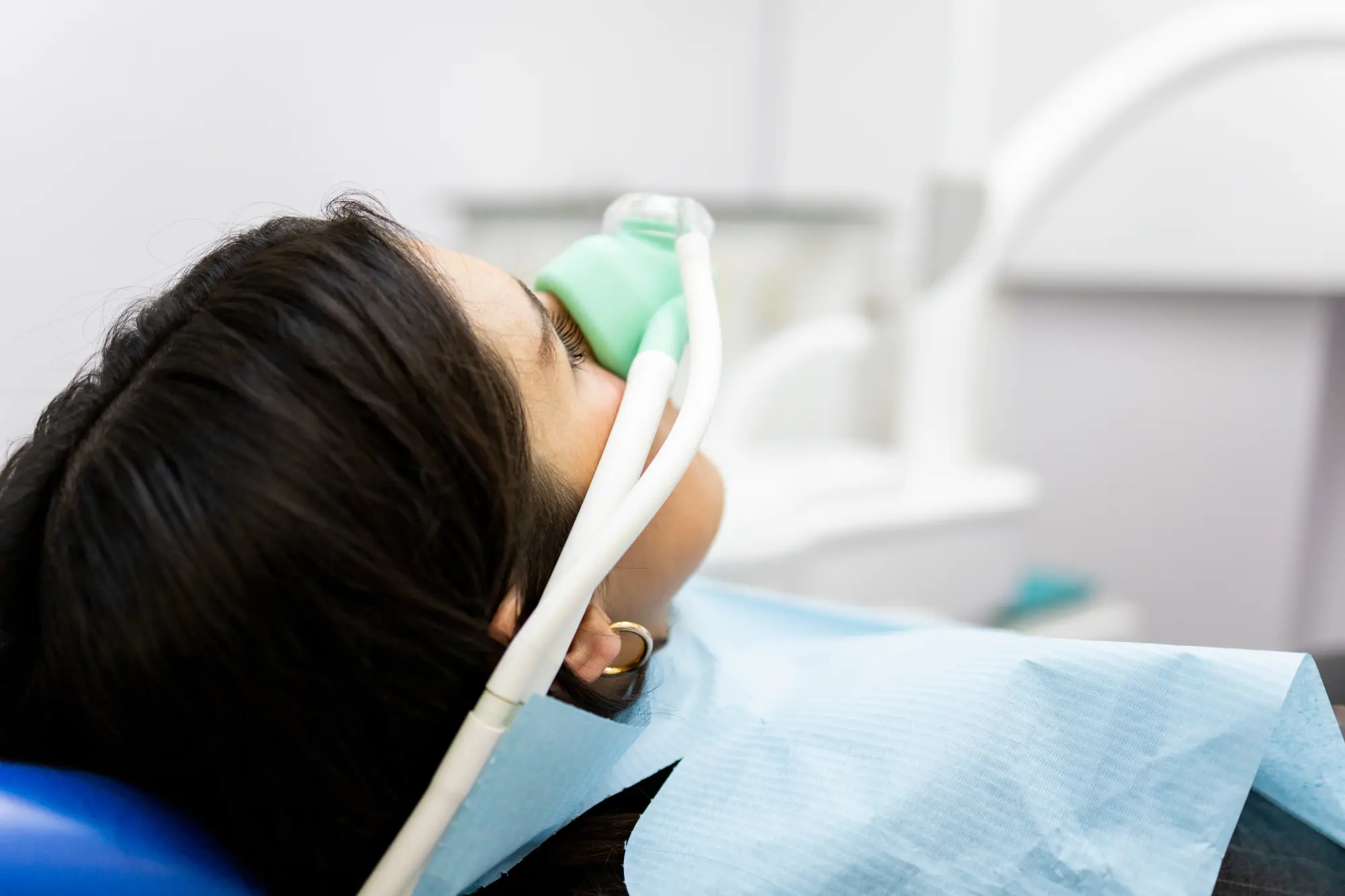 Image of european woman sitting in dental chair while professional doctor fixing her teeth